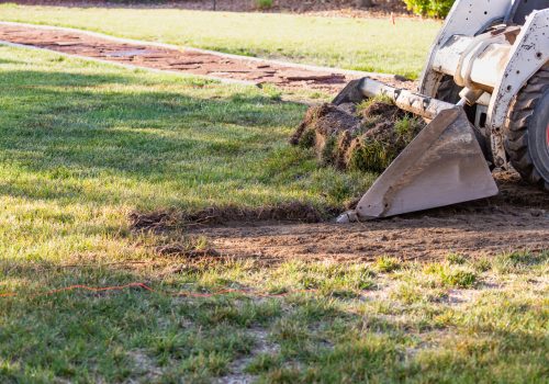 Small Bulldozer Removing Grass From Yard Preparing For Pool Installation